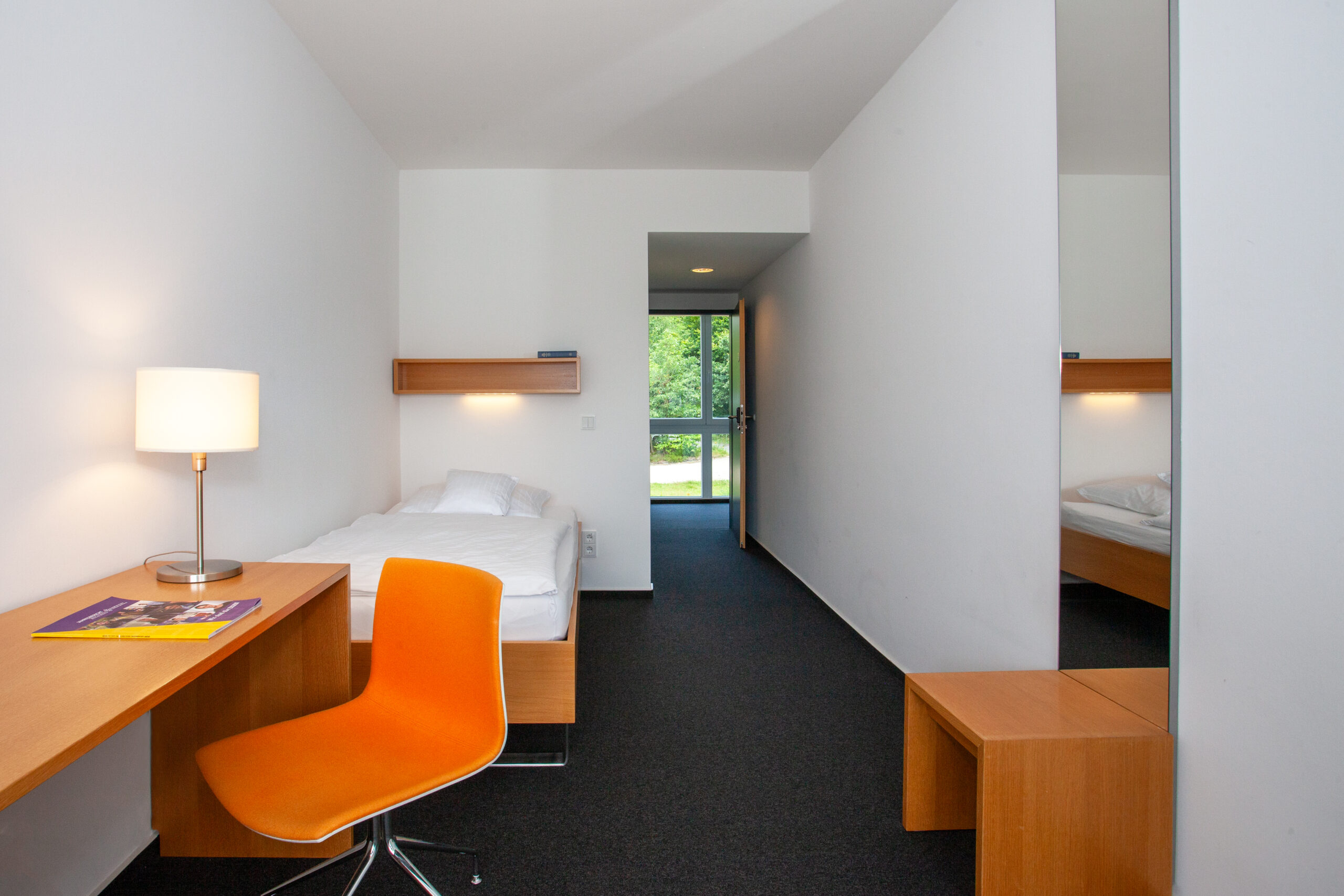 Zimmeransicht mit Schreibtisch und Bett